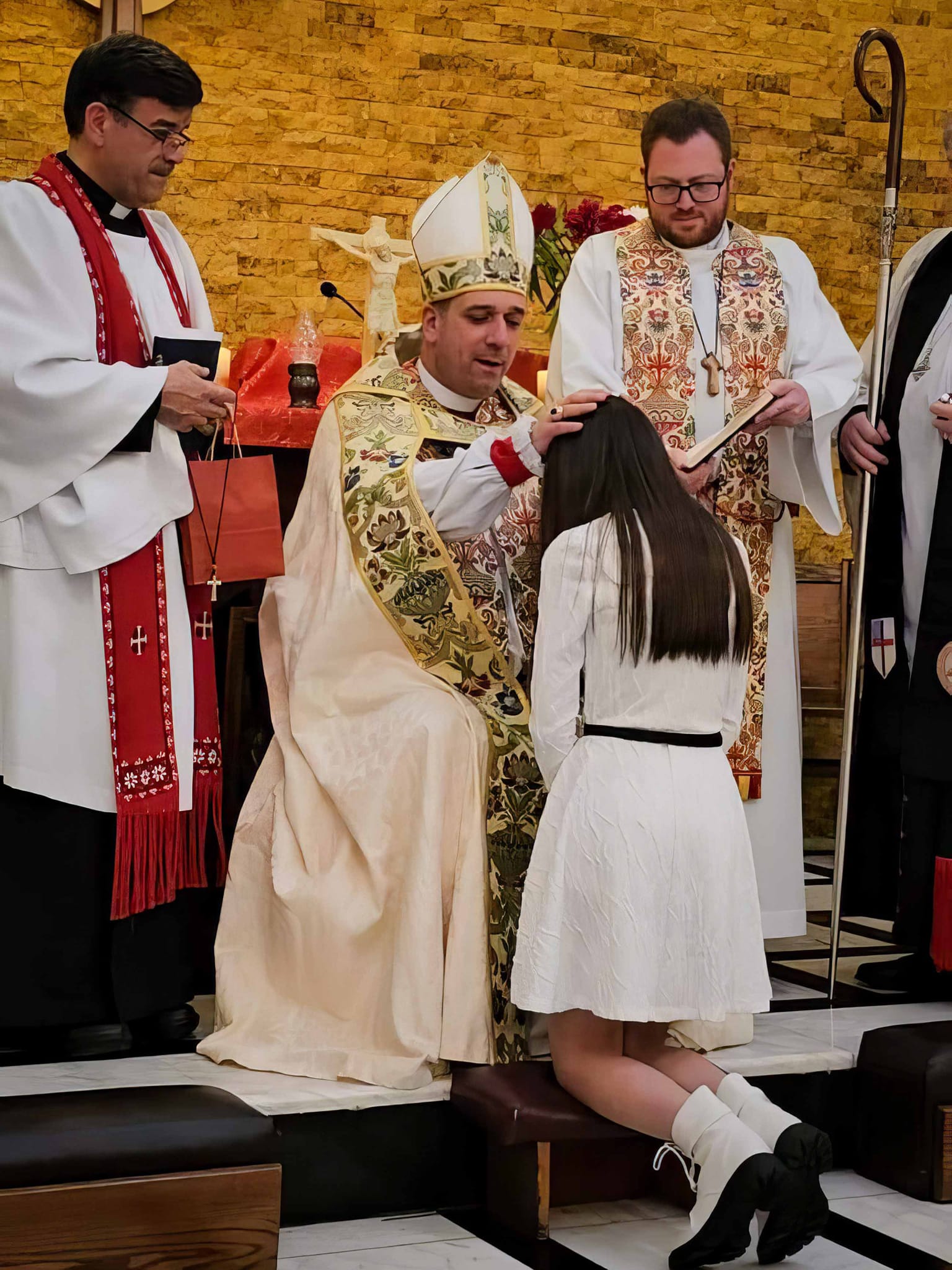 Bishop Hosam lays hand on young lady as he baptizes her
