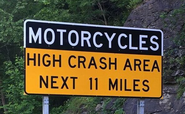 sign on the tail of the dragon roadway that reads Motorcycles High Crash Area Next 11 Miles